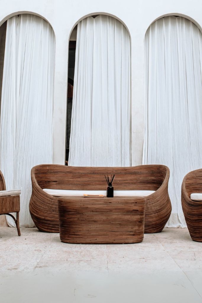 Handmade brown round rattan sofa Tegal with ecru cushions, designed for eco-friendly outdoor living on patios and terraces
