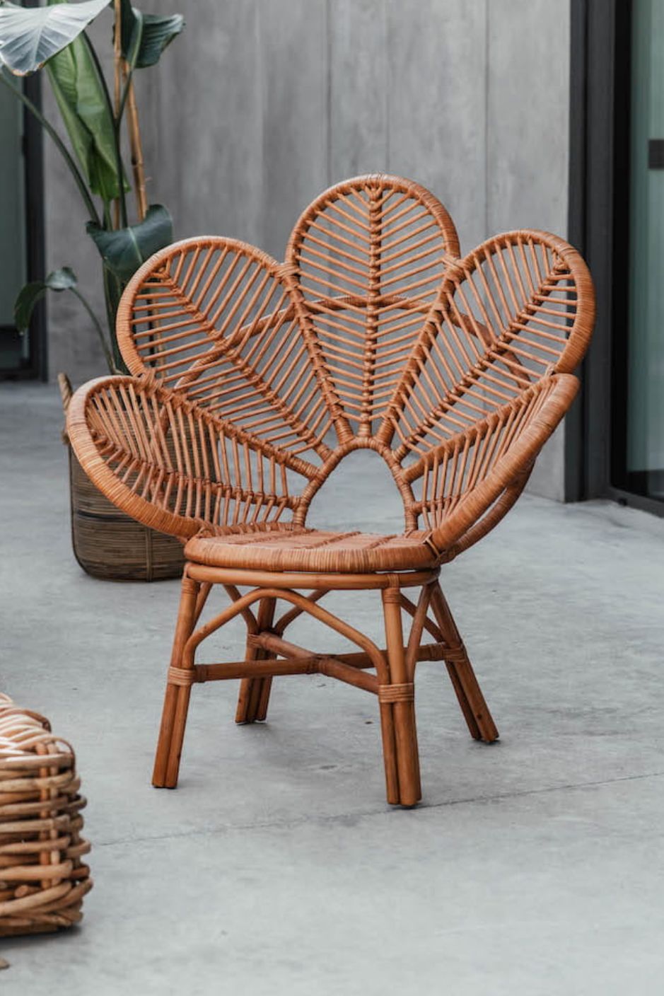 Rattan Monna Flower Chair featuring a handcrafted petal-shaped backrest and natural rattan weave, offering elegant bohemian style for indoor or outdoor spaces