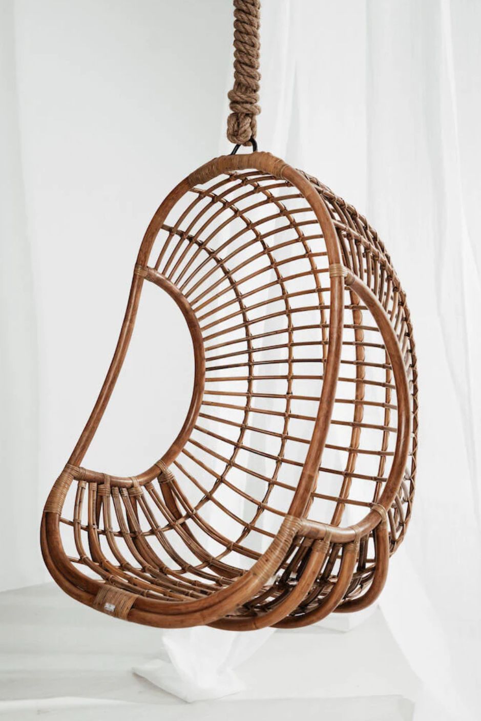 Hugo Rattan Hanging Chair in natural, cognac and brown rattan, handmade, eco-friendly, zero plastic, boho style, perfect for living room, terrace, or patio, stylish and comfortable swinging chair for modern or island-inspired interiors.