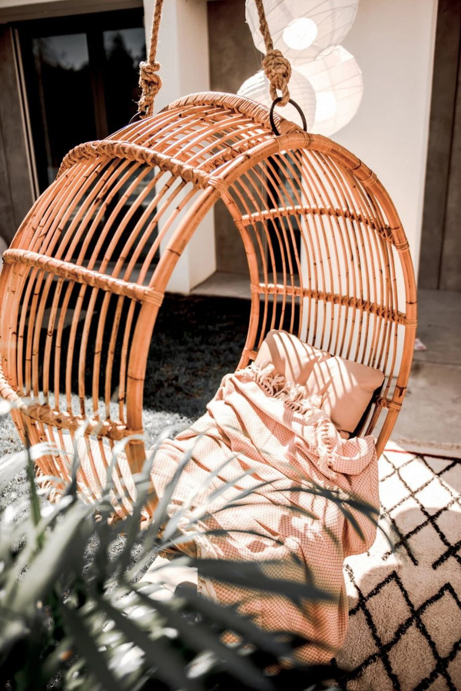 Durable handmade cognac rattan hanging swing chair single, designed for relaxing indoor or outdoor comfort.
