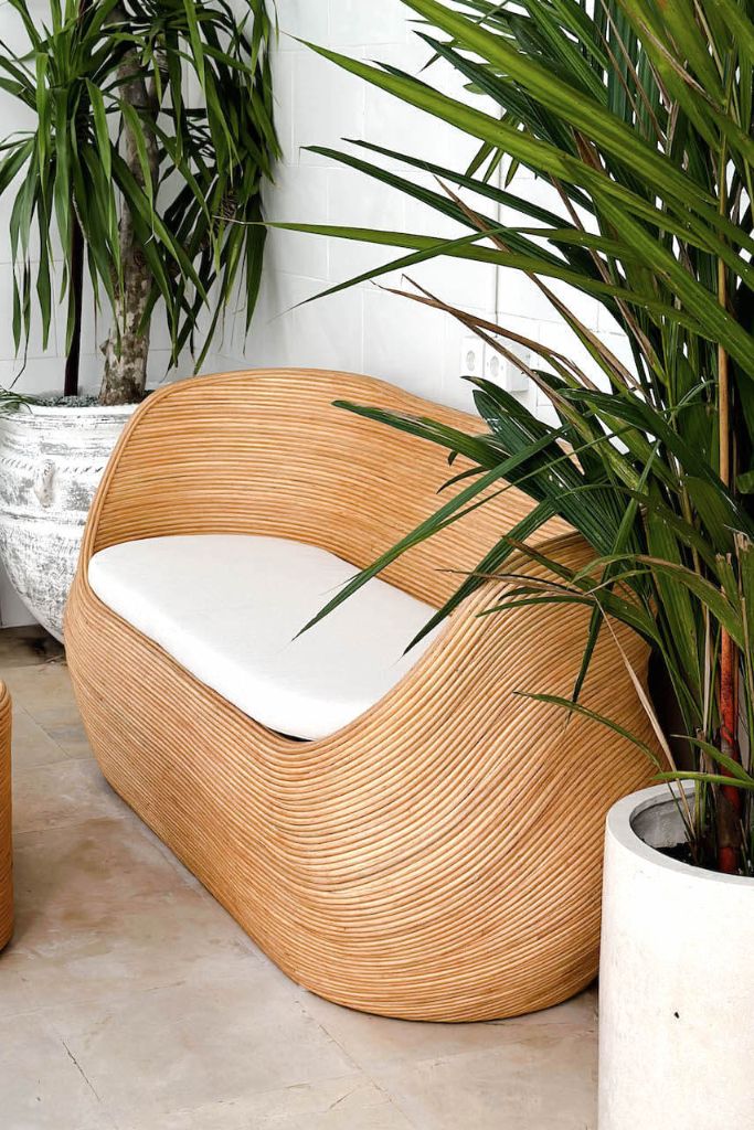 Handmade natural round rattan sofa Tegal with ecru cushions, designed for eco-friendly outdoor living on patios and terraces