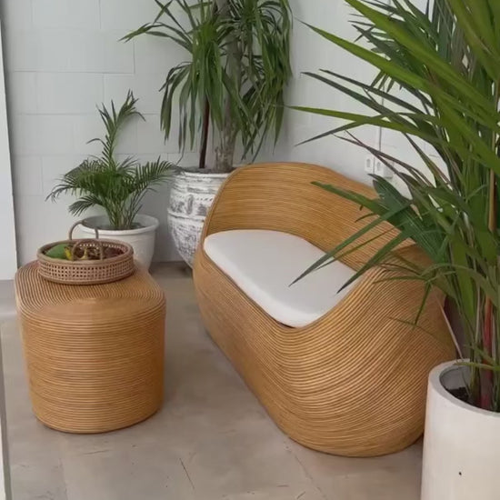 Handmade natural round rattan sofa Tegal with ecru cushions, designed for eco-friendly outdoor living on patios and terraces