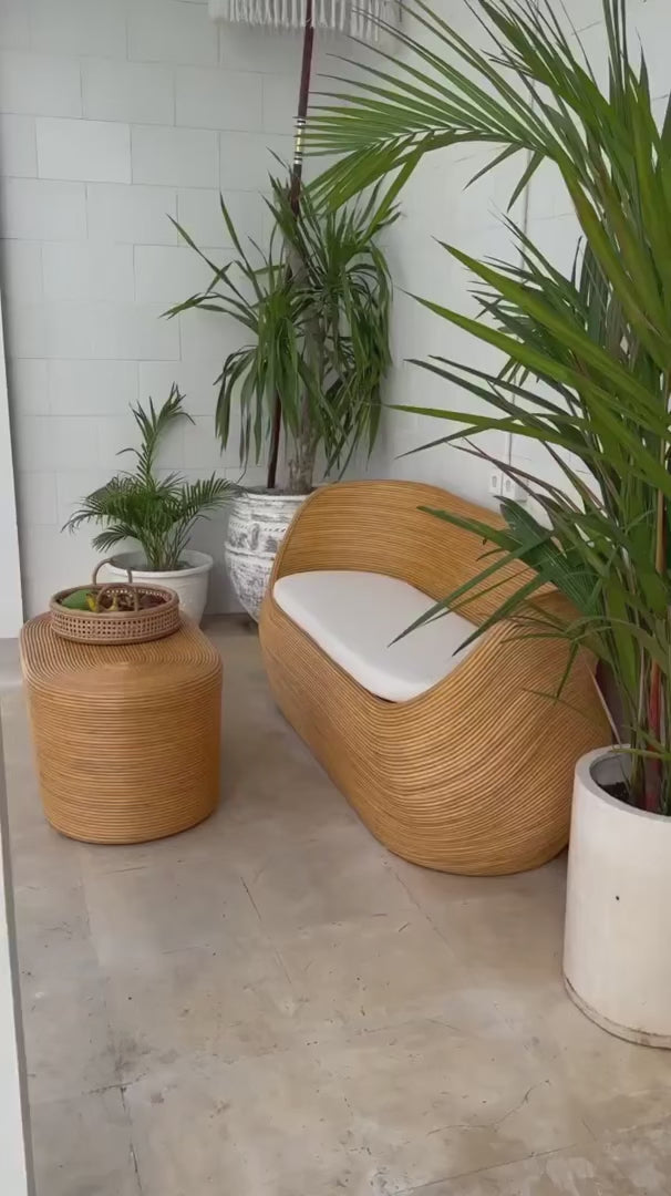 Handmade natural round rattan sofa Tegal with ecru cushions, designed for eco-friendly outdoor living on patios and terraces