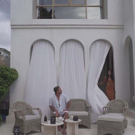 Handcrafted Tyo rattan armchair with curved armrests and woven headrest in natural autumn tones