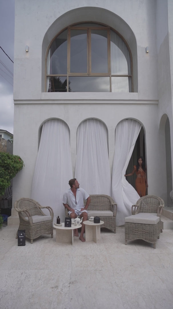 Handcrafted Tyo rattan armchair with curved armrests and woven headrest in natural autumn tones