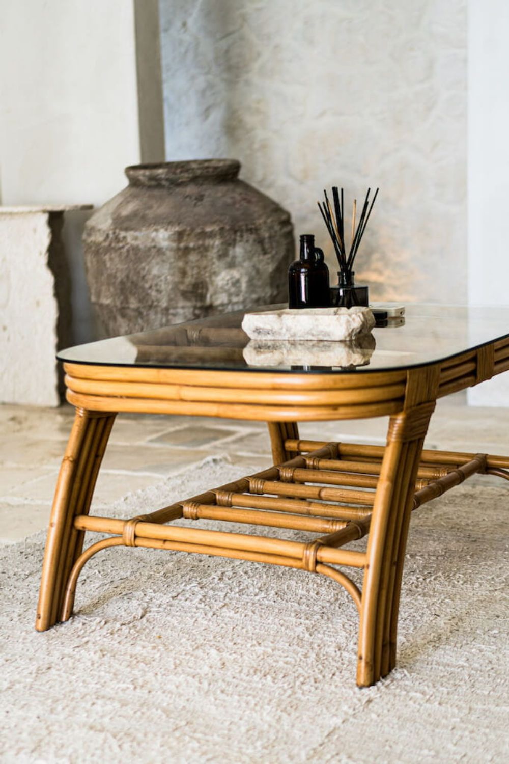 Handcrafted Sali rattan table with thick glass top and central shelf, featuring opalescent natural tones and elegant, unique design.