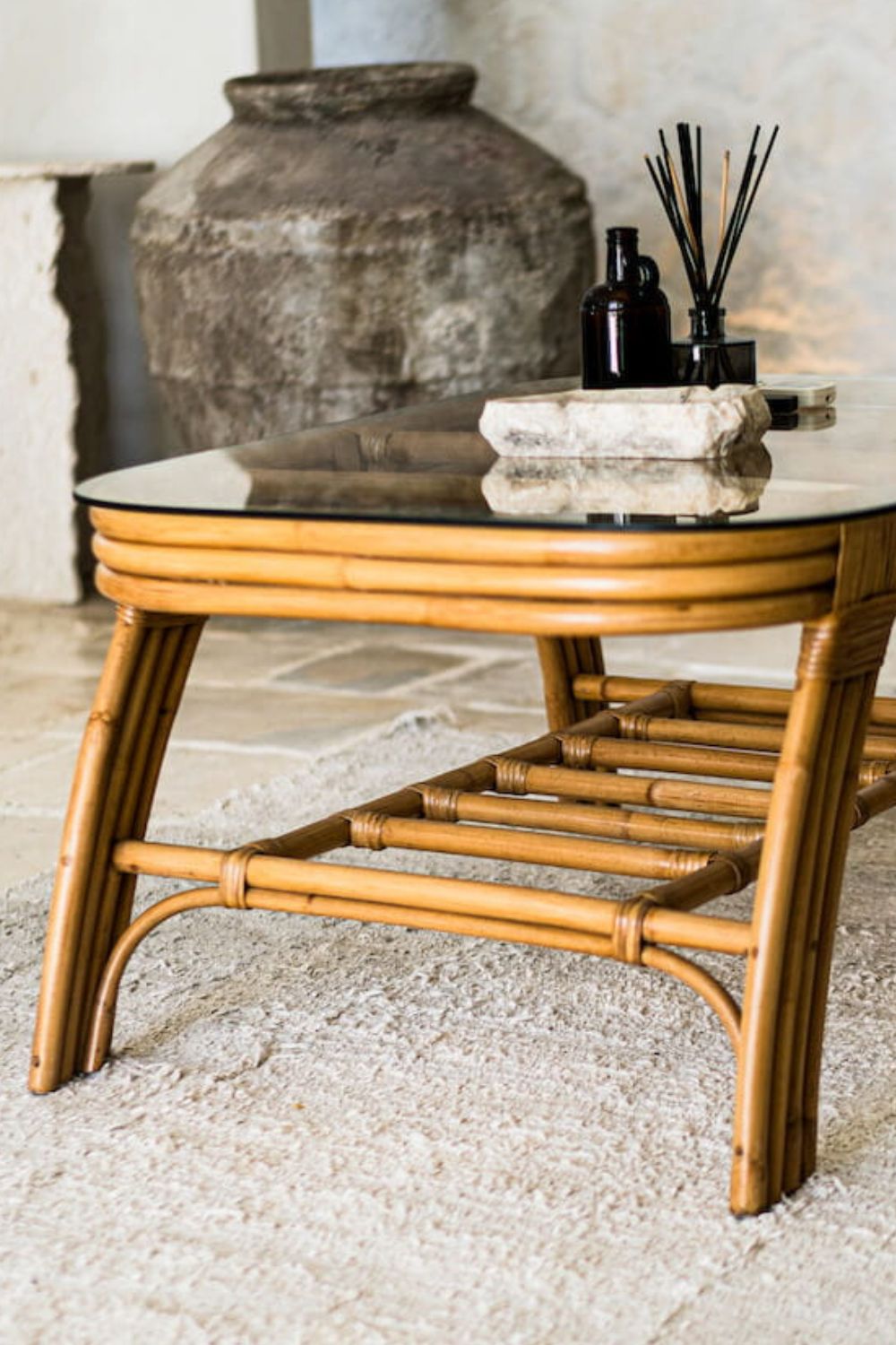 Handcrafted Sali rattan table with thick glass top and central shelf, featuring opalescent natural tones and elegant, unique design.
