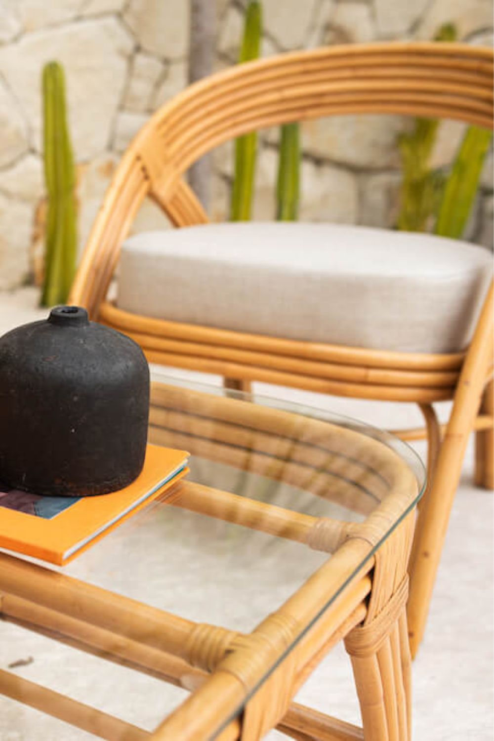 Handcrafted Sali rattan table with thick glass top and central shelf, featuring opalescent natural tones and elegant, unique design.