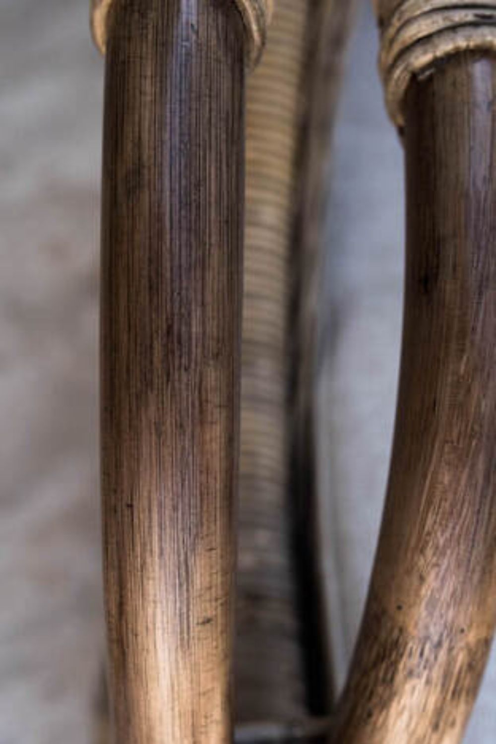 Handcrafted Tyo rattan armchair with curved armrests and woven headrest in natural autumn tones