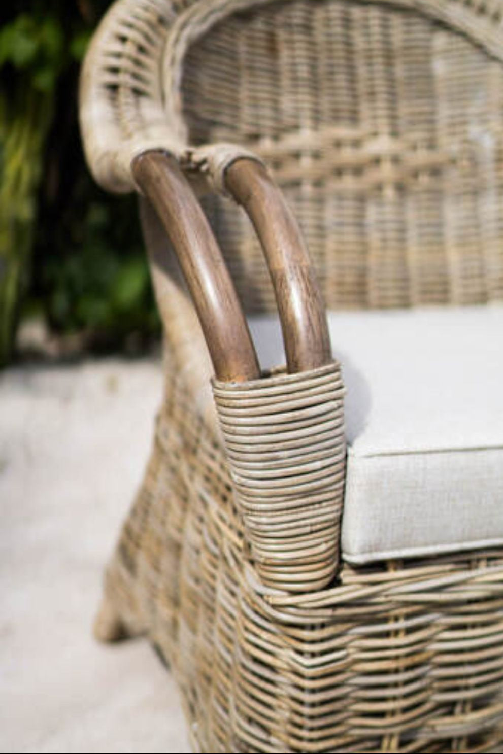 Handcrafted Tyo rattan armchair with curved armrests and woven headrest in natural autumn tones