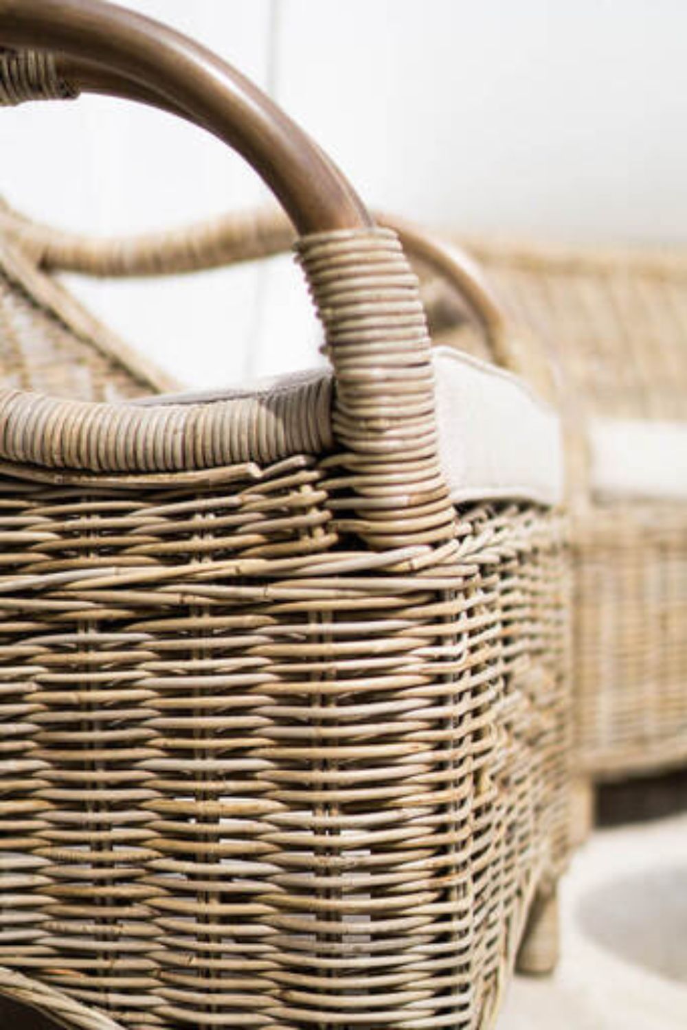 Handcrafted Tyo rattan armchair with curved armrests and woven headrest in natural autumn tones