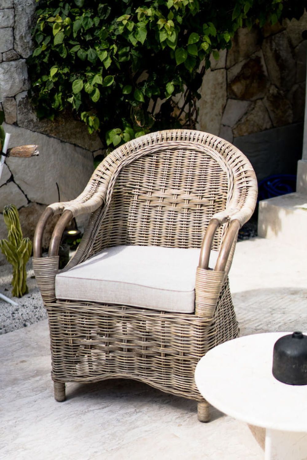 Handcrafted Tyo rattan armchair with curved armrests and woven headrest in natural autumn tones